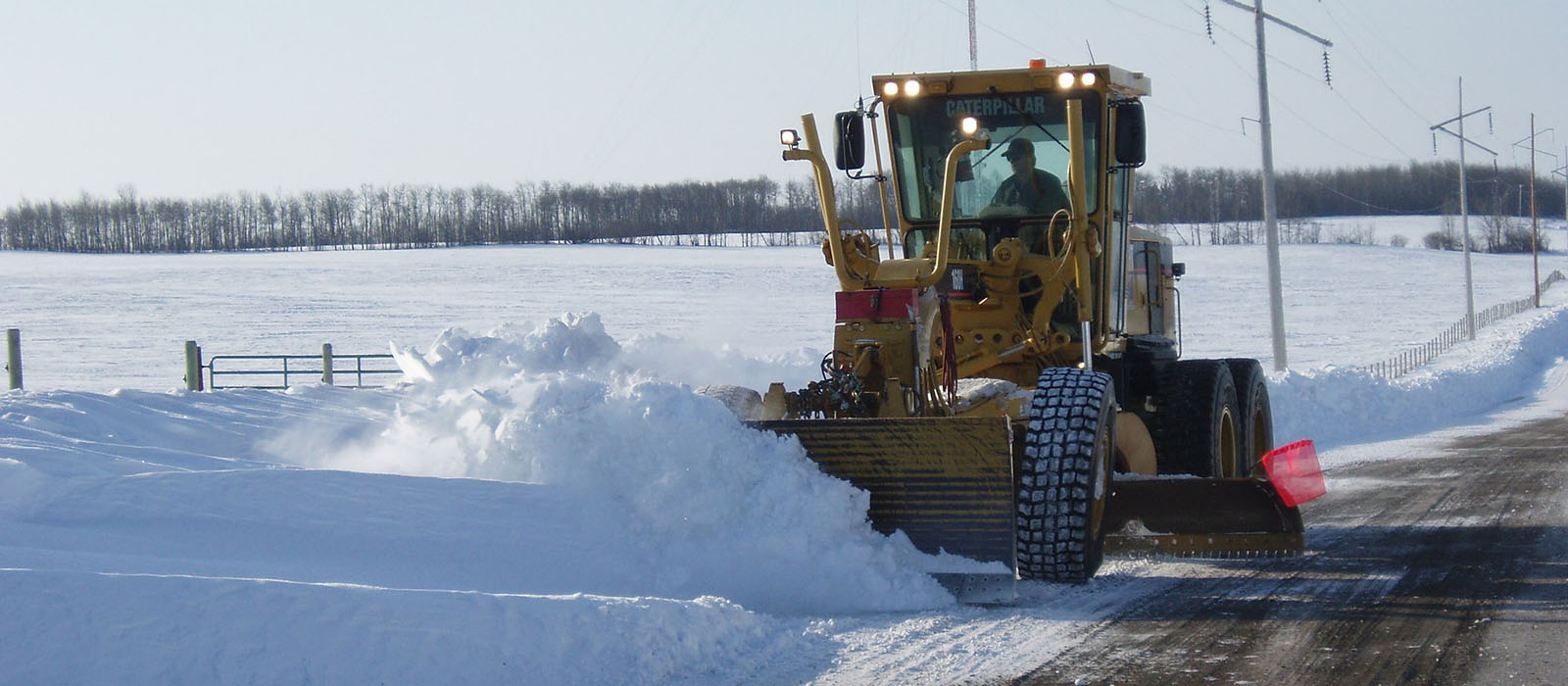 Grader plowing snow