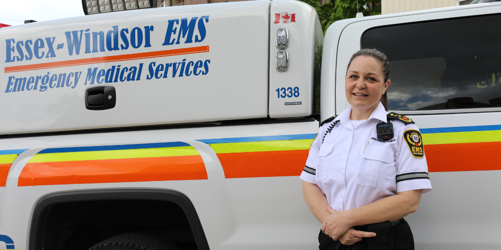 An Essex-Windsor EMS district chief standing next to her vehicle.