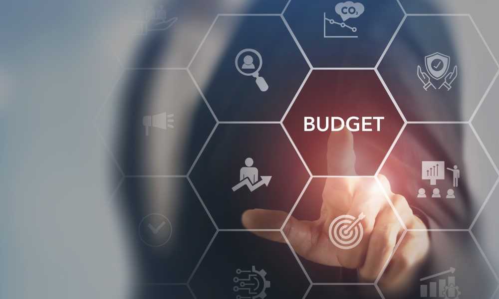 A hand touching the word "budget"