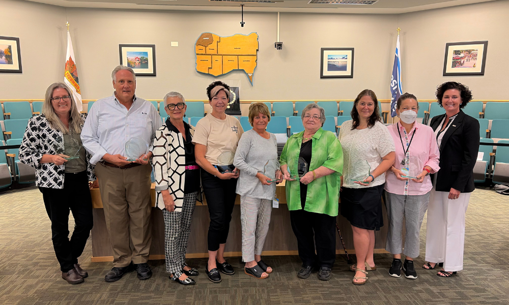 Members of the Essex County Accessibility Advisory Committee pose with glass awards with the Warden in Council Chambers.