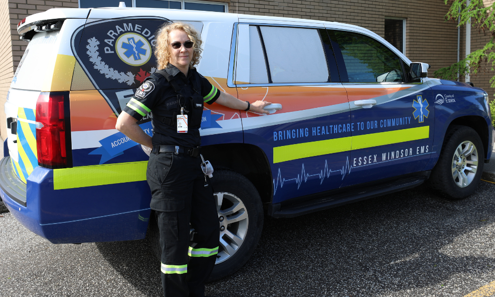 A member of the Essex-Windsor EMS Mobile Integrated Healthcare Community Paramedicine team next to her vehicle.