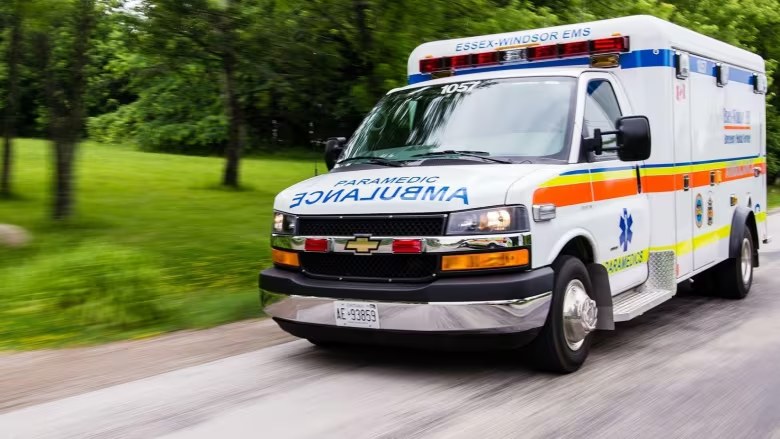 An ambulance against a blurred green background, suggesting speed.