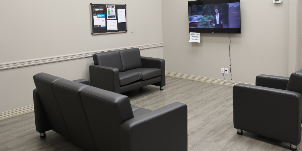 A couch, chair and TV in the Homelessness Hub.