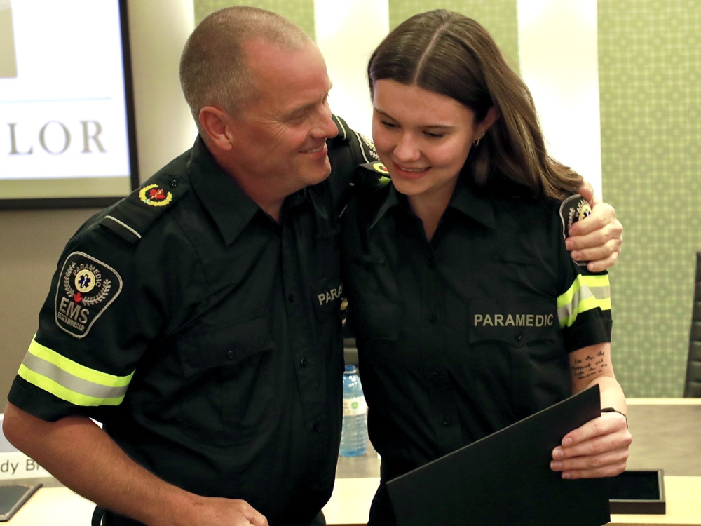 A Paramedic hugs a new paramedic recruit family member