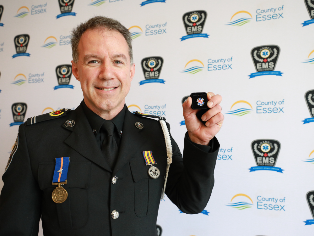 Paramedic Rick St. Pierre holds his 20 save pin.