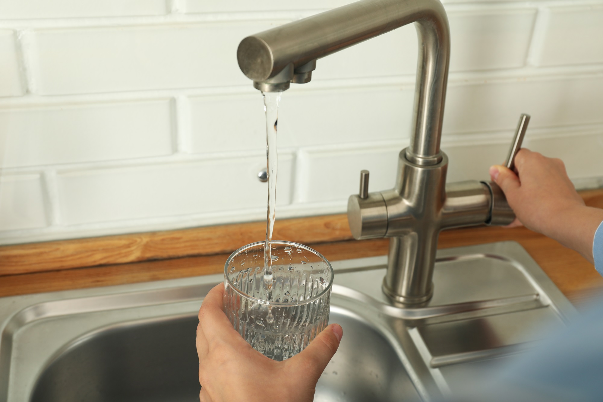 stylish metal faucet and water glass