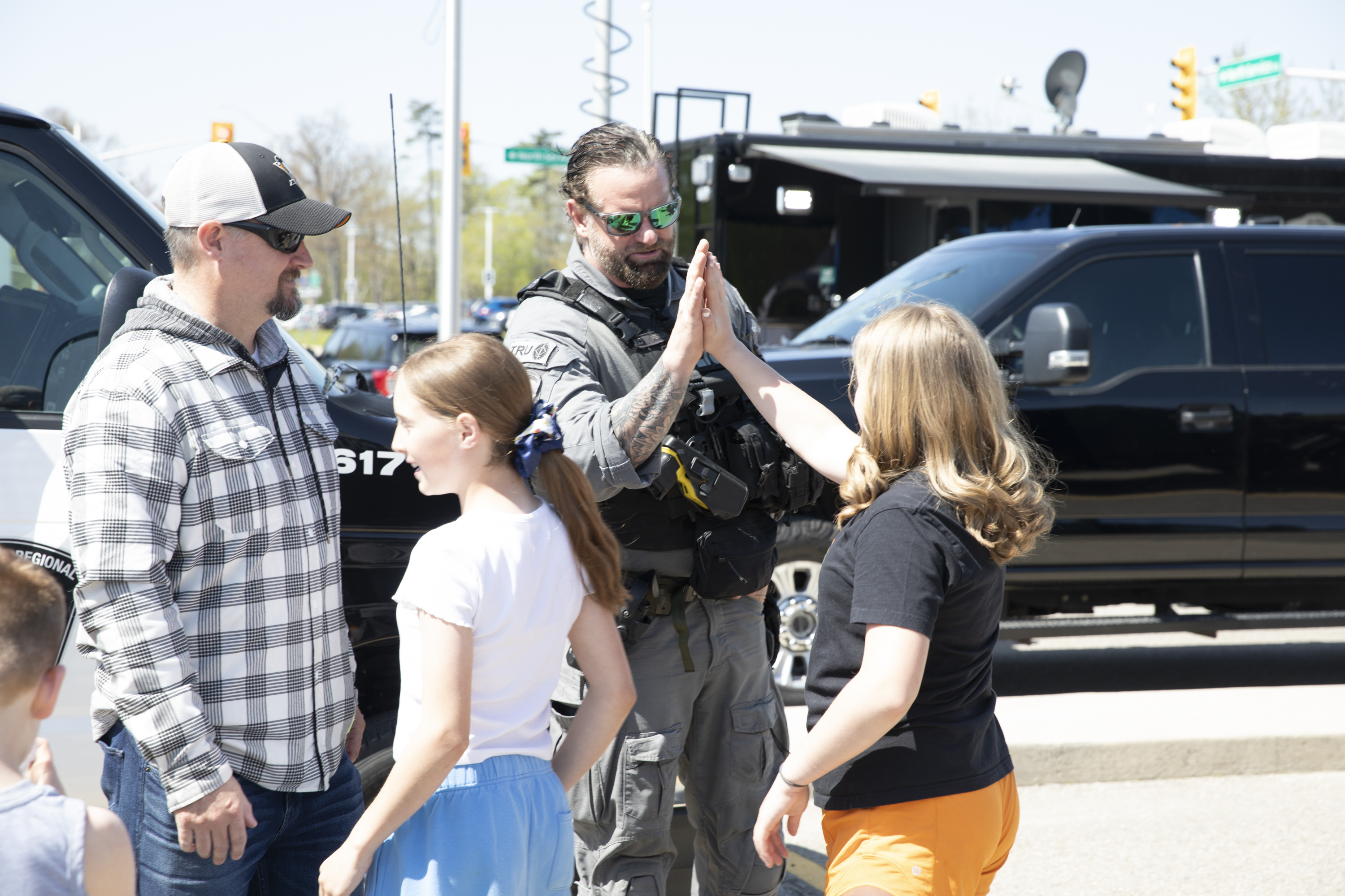Officer high-fiving a young girl at Police Day