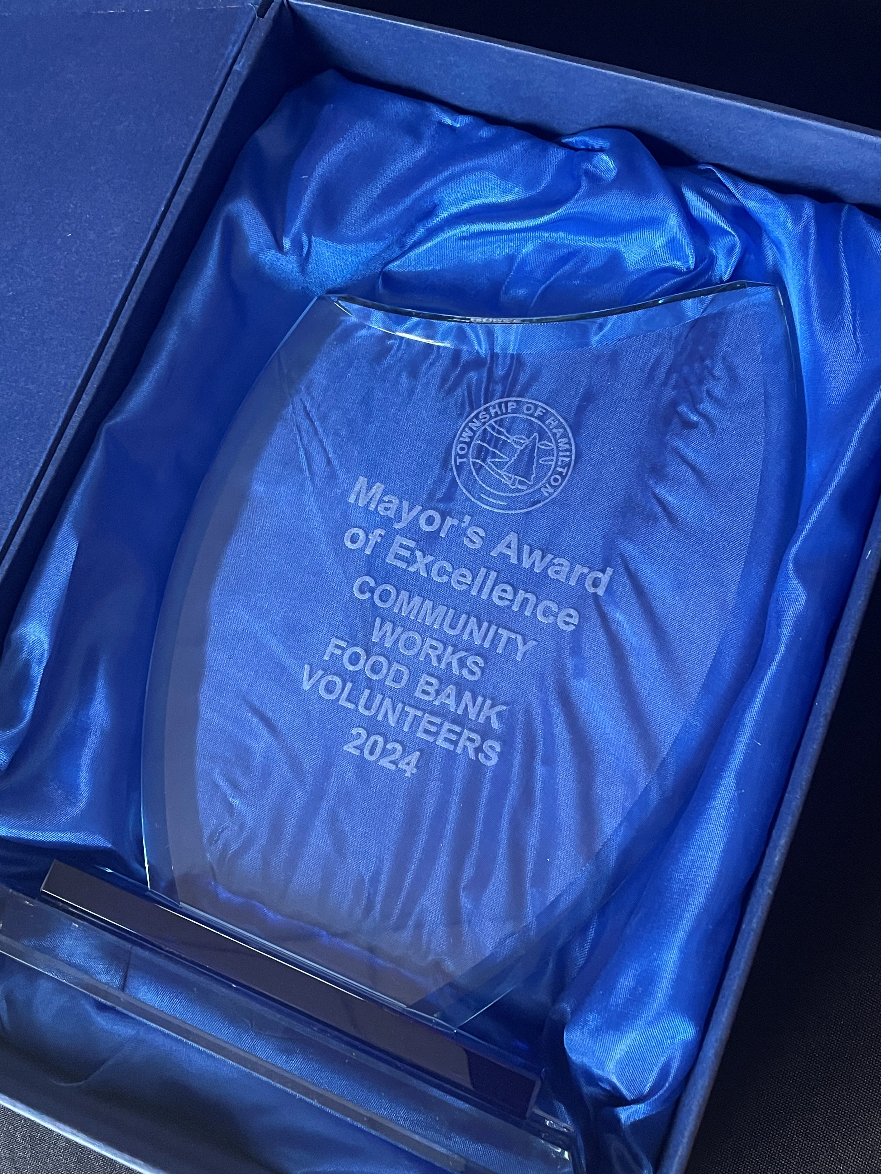 a glass award engraved with the Mayor's Award of Excellence