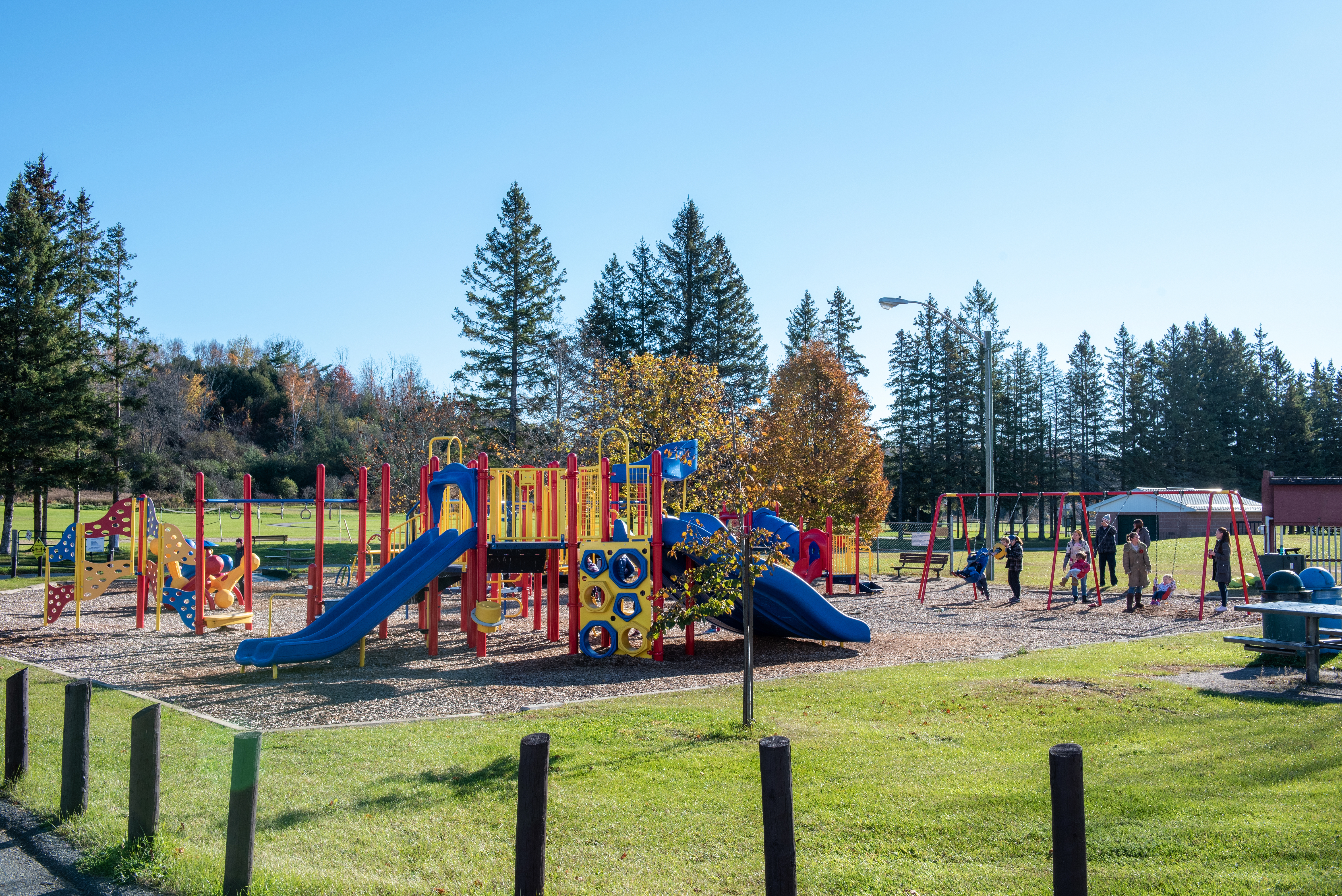 Baltimore arena playground from afar with children playing on swings and climbing structures