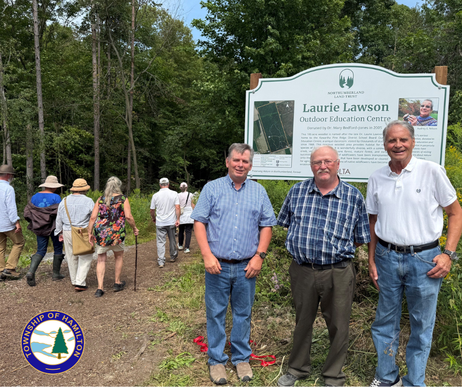 Members of Council stand in front of the new Laurie Lawson Outdoor Education Centre sign and trailhead