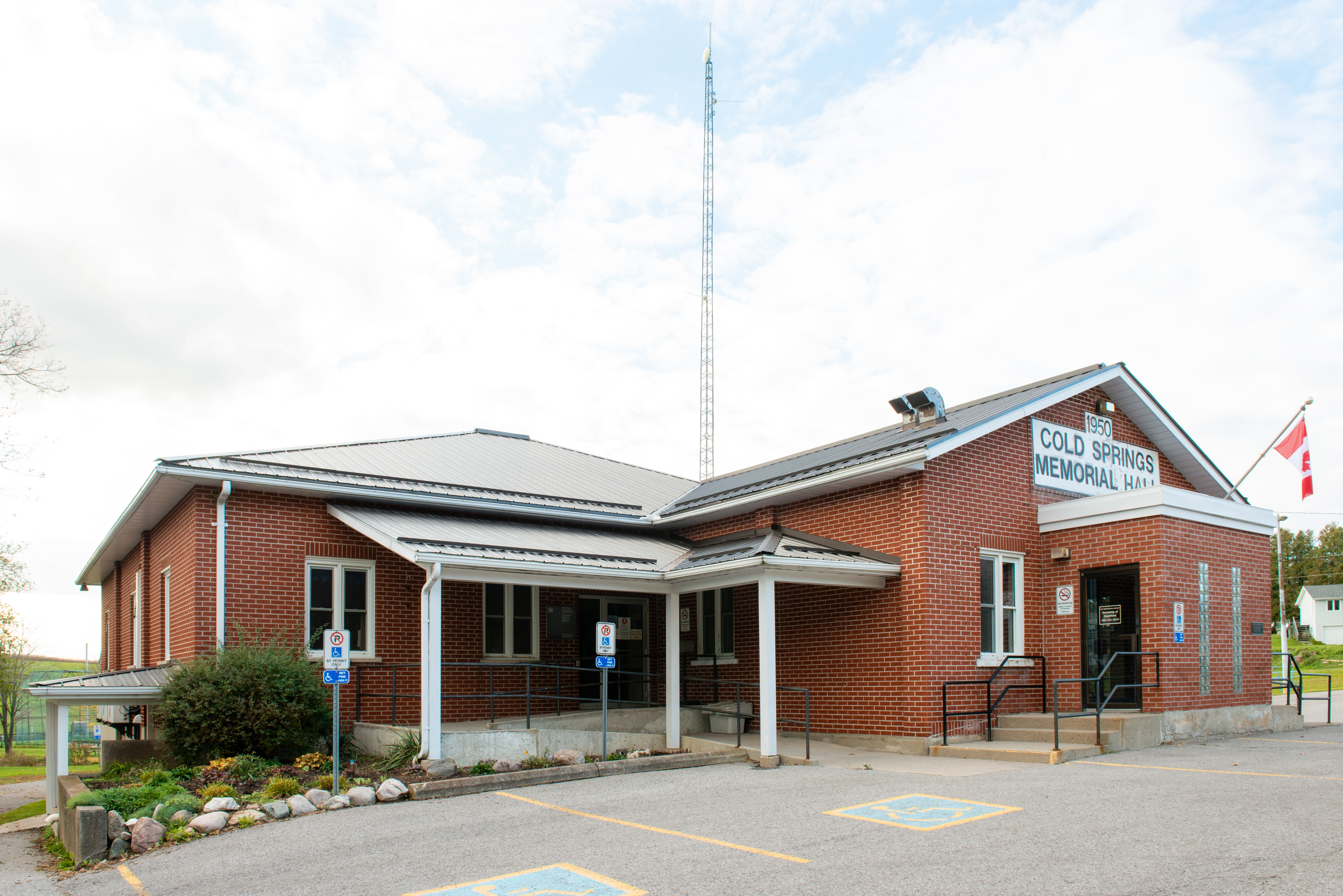 Exterior of Cold Springs Memorial Hall featuring accessible parking spaces and greenery
