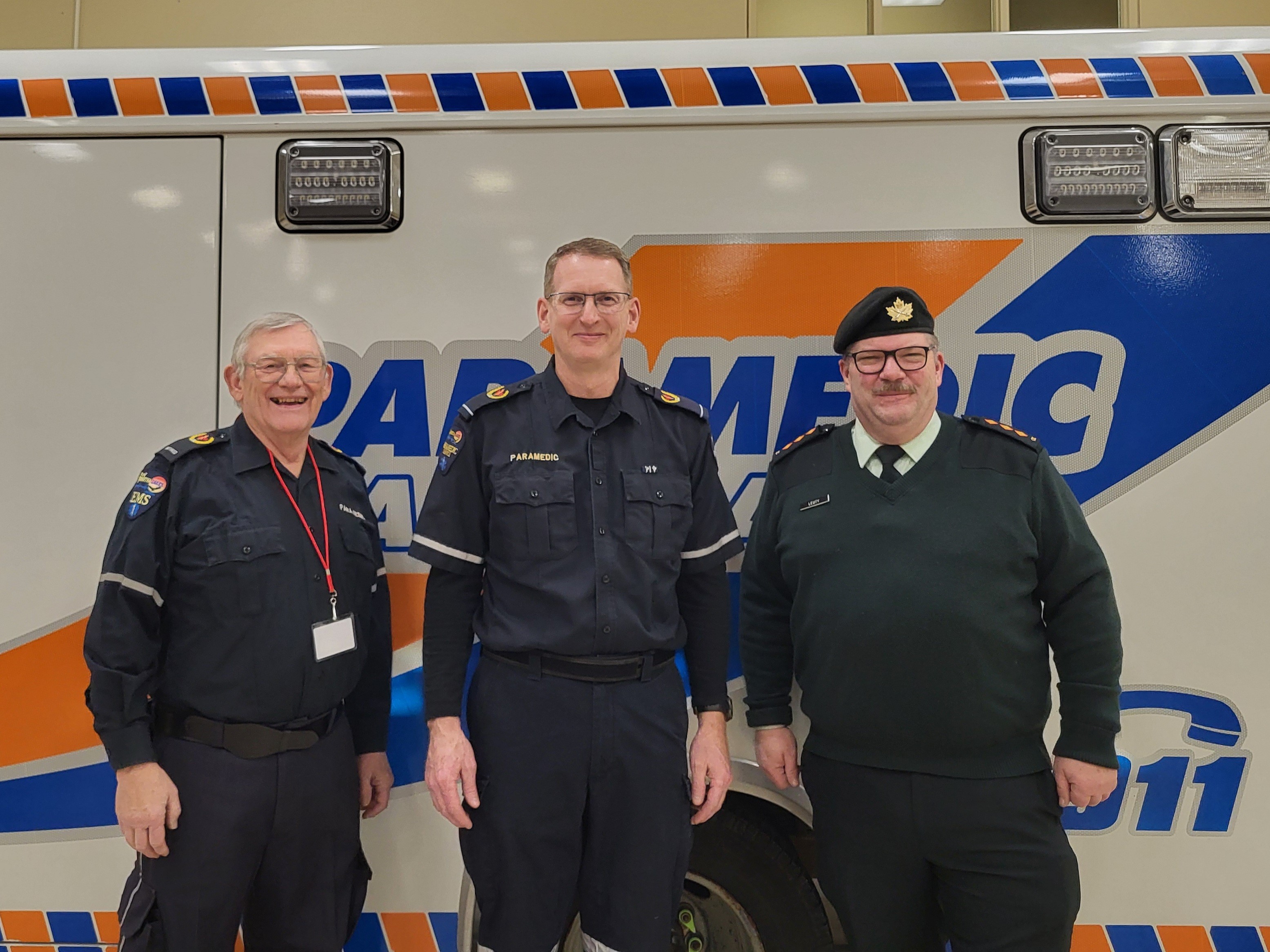 Three paramedics standing infront of an ambulance