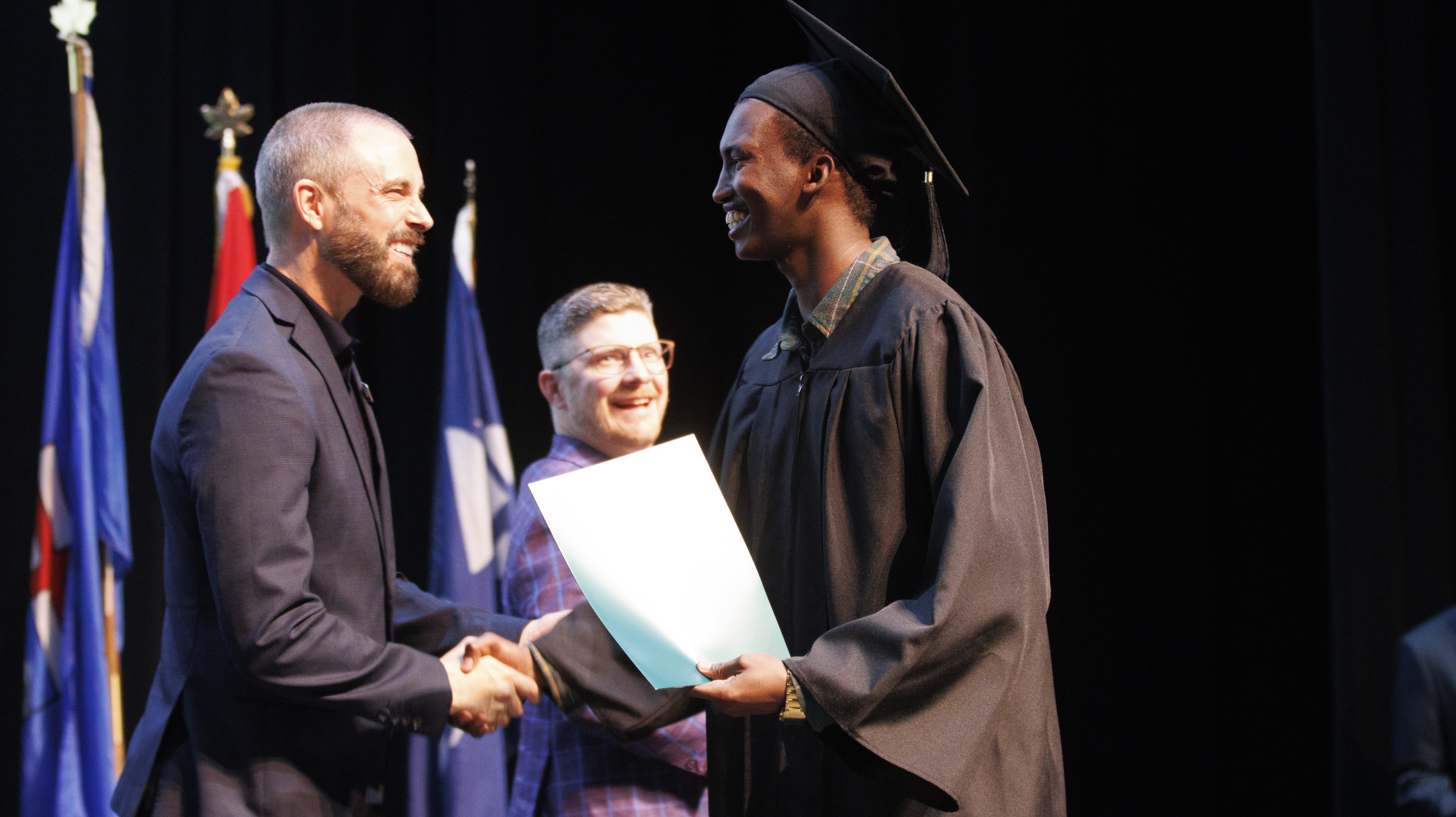 Keyano College President congratulating a graduate on stage during convocation.