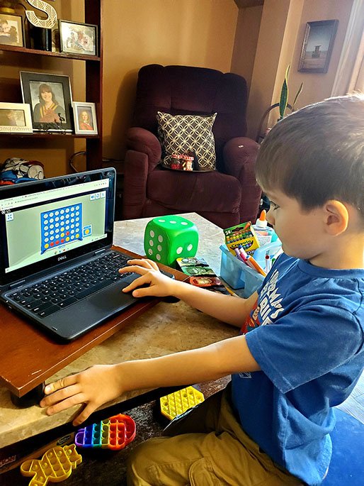 Picture of young student working on laptop at home