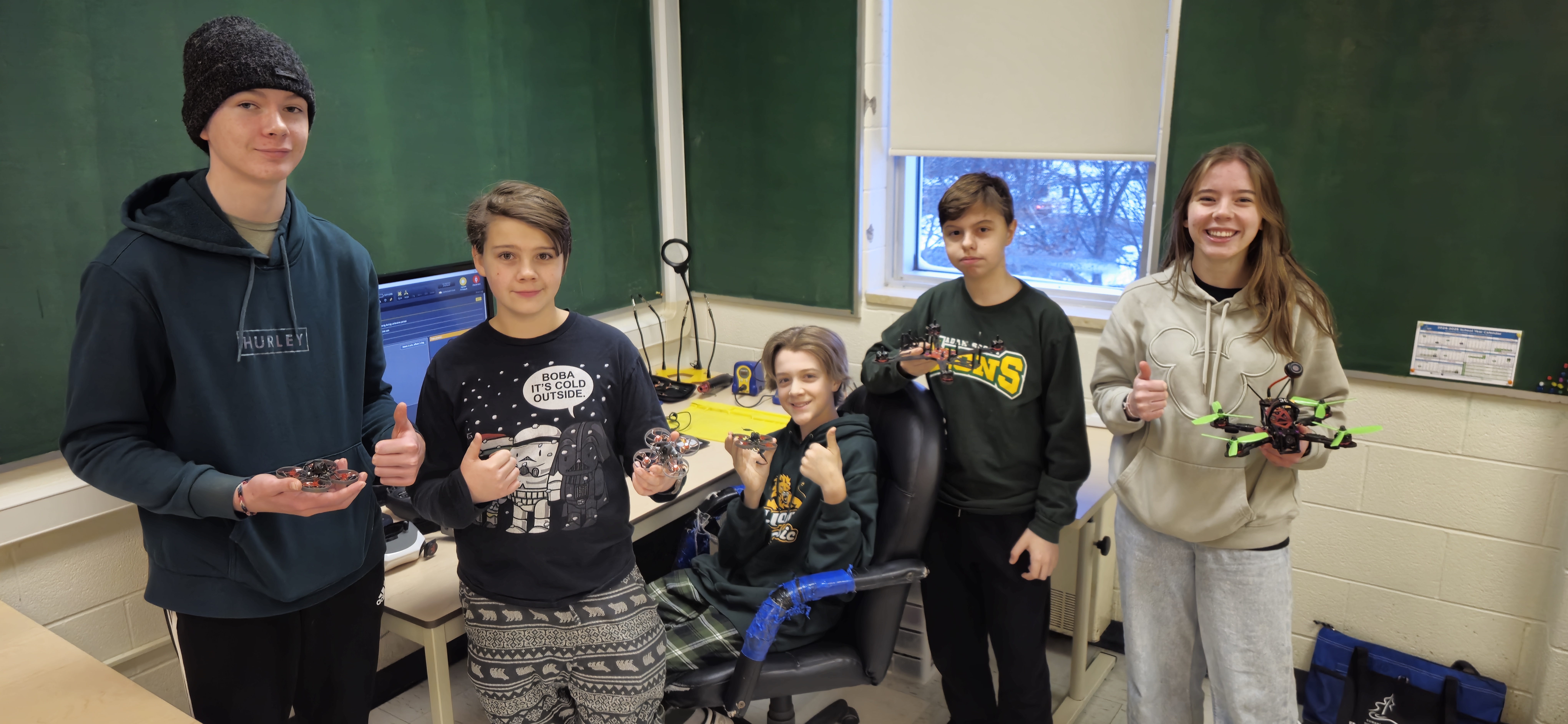 group of students holding drones