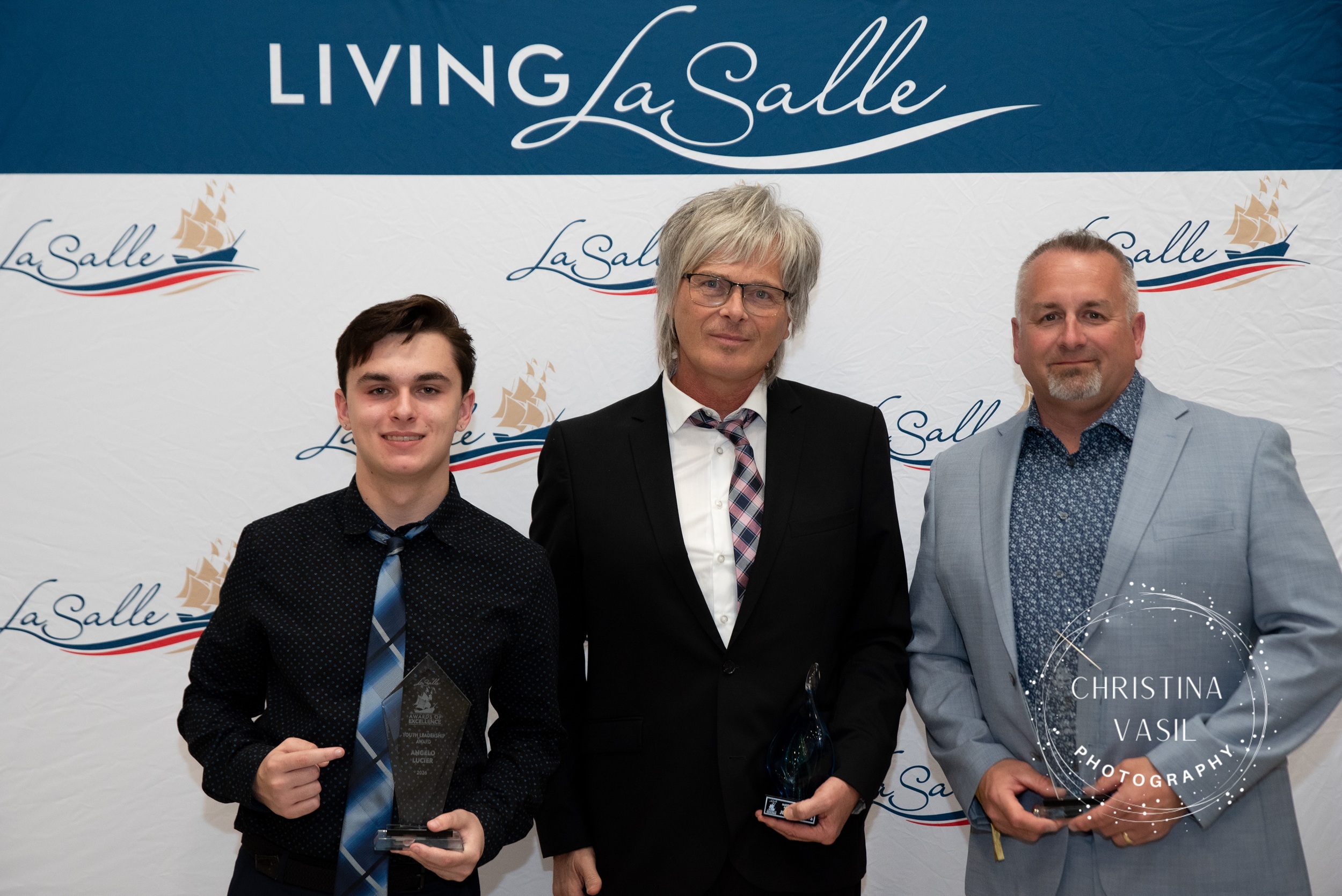 3 people, posing with award