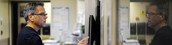 our services banner with person closely monitoring the screen for results