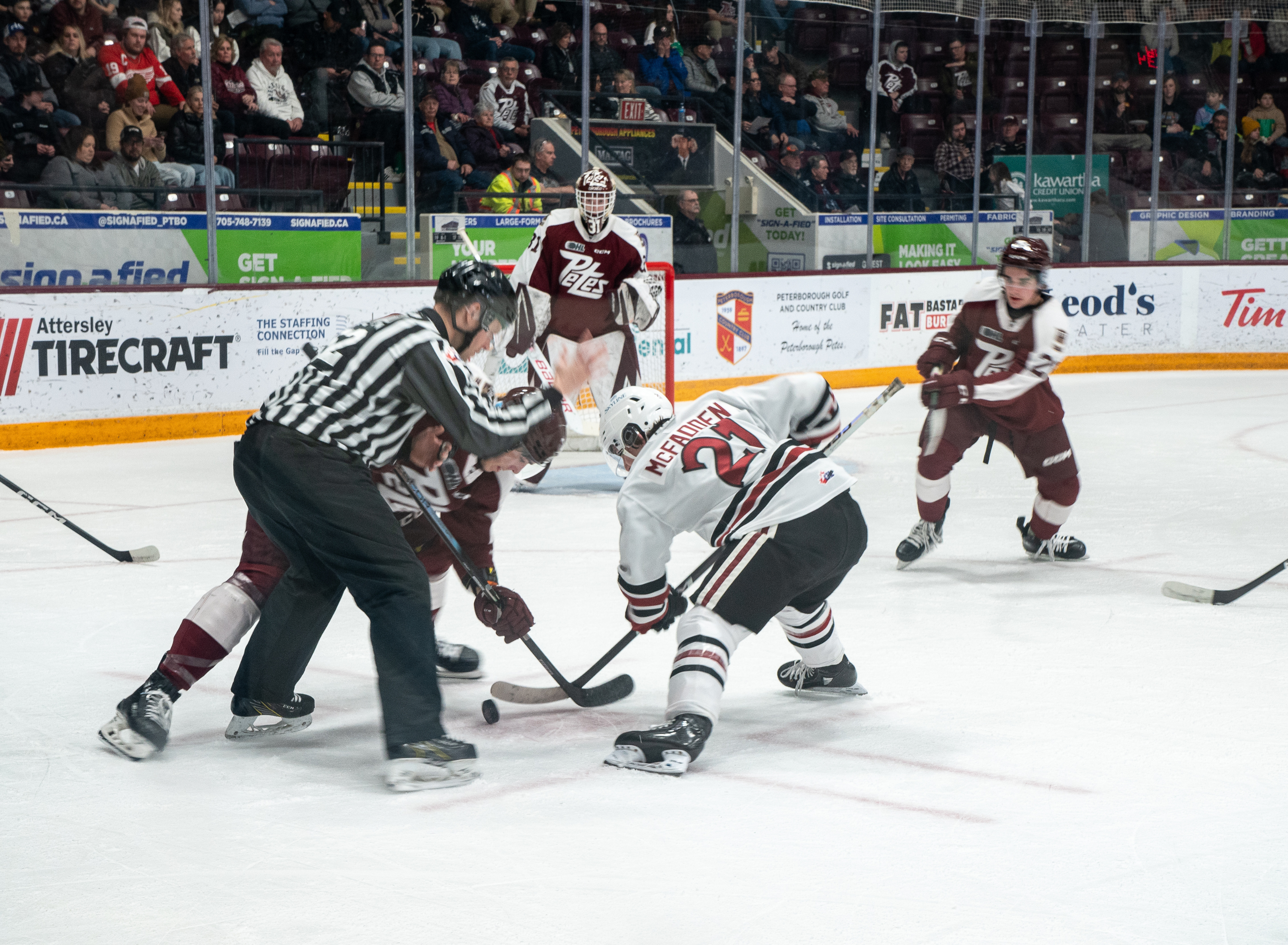 OHL Ice Hockey Game in Peterborough. Two opposing team players face off at a Peterborough Petes 'home game'.