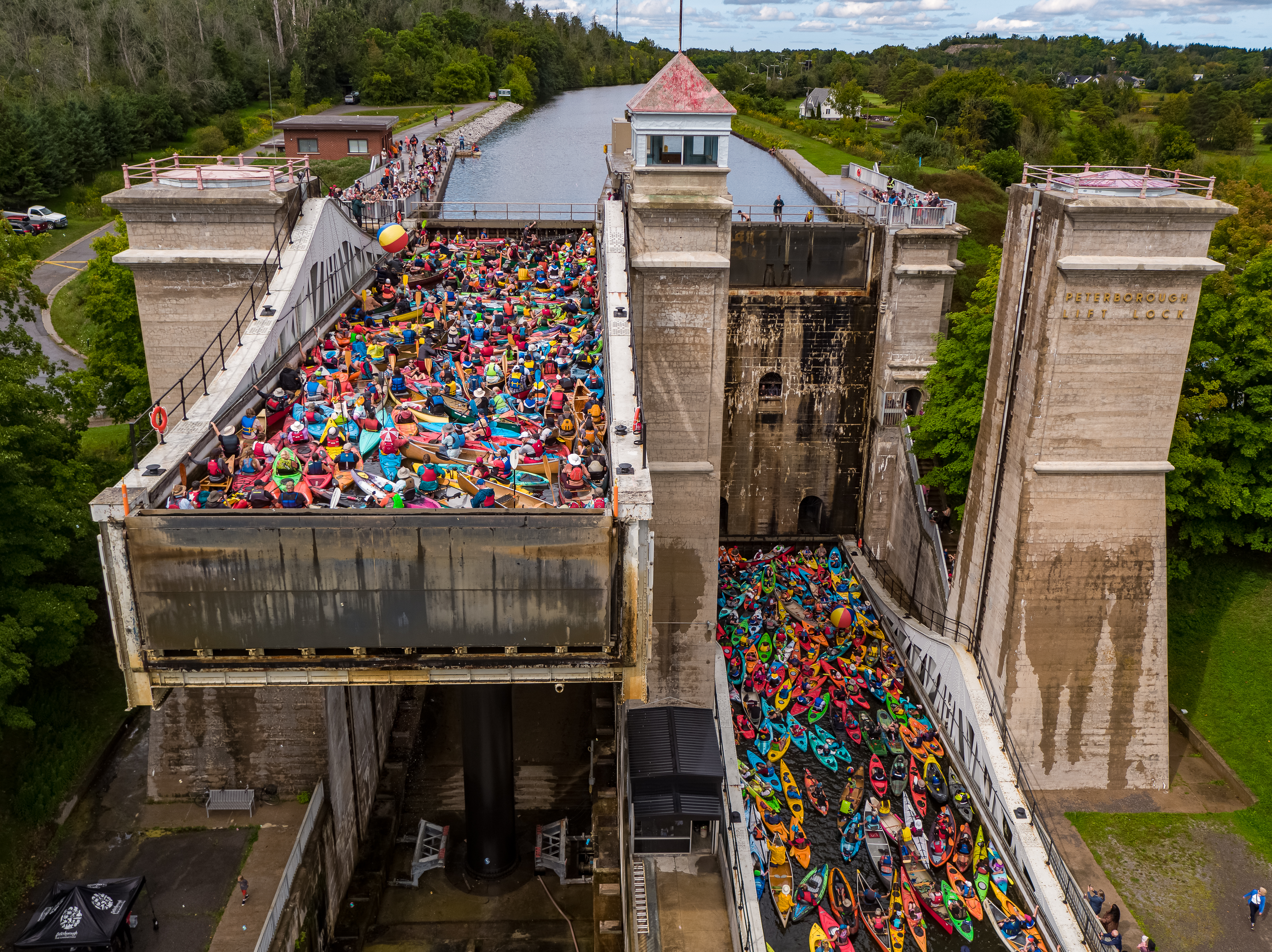 Image of the Peterborough Lift Lock, Lock 21, with one up and one down. It is full of brightly coloured canoes and kayaks.