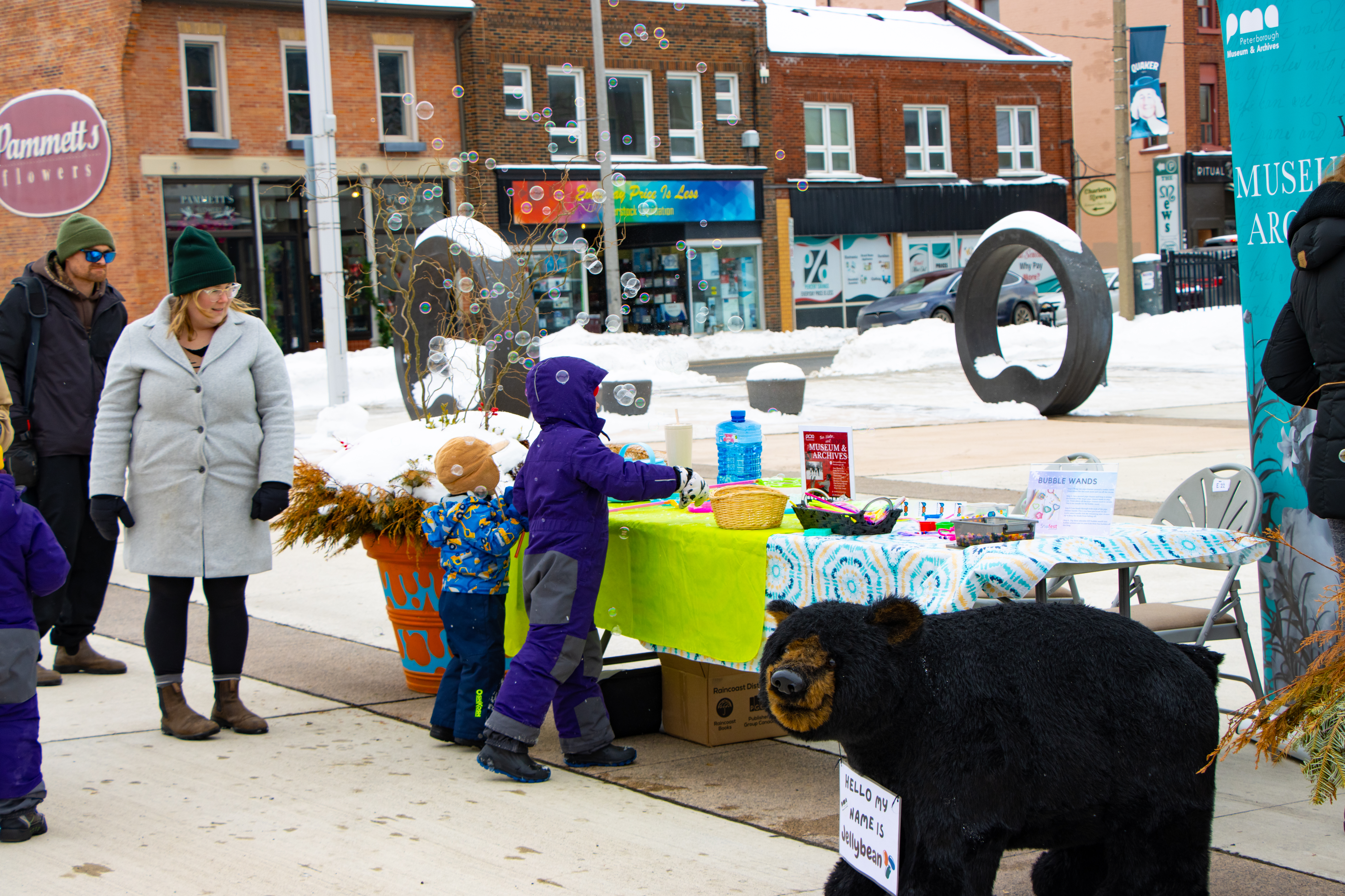 Young children participate in a frozen bubbles activity during Snofest outdoor festivities