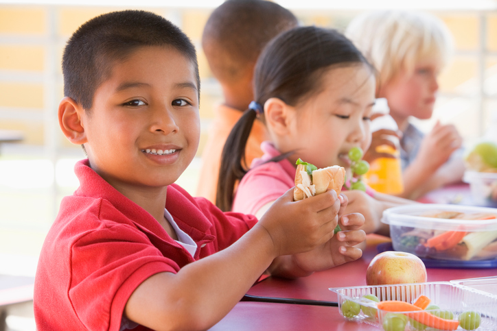 Four children seated at table eating lunch