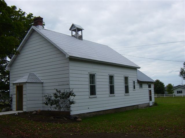 Photo of historic schoolhouse with white siding