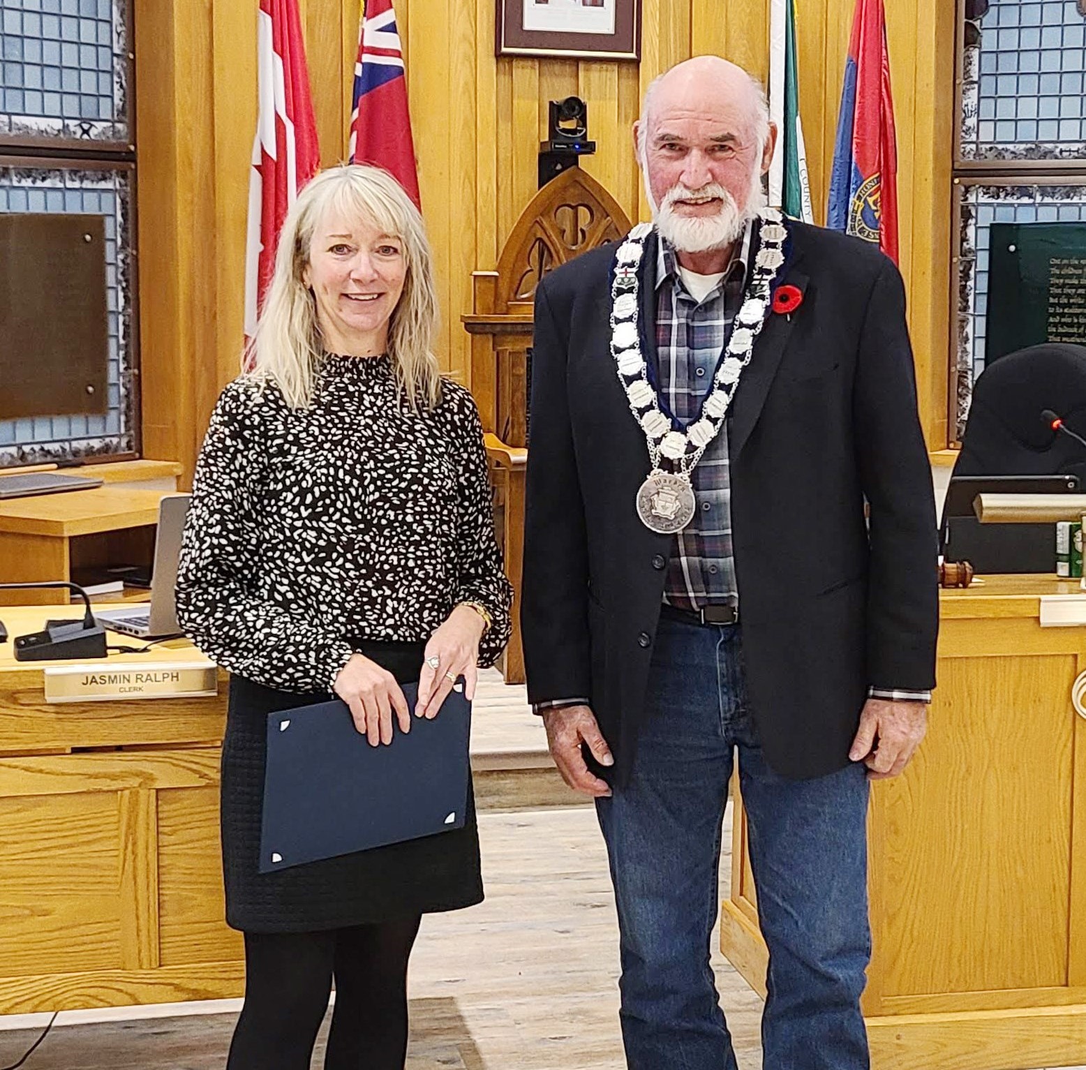 Lanark County Warden Peter McLaren, right, presents an Award of Excellence to Mississippi Mills Public Library CEO Christine Row, left.