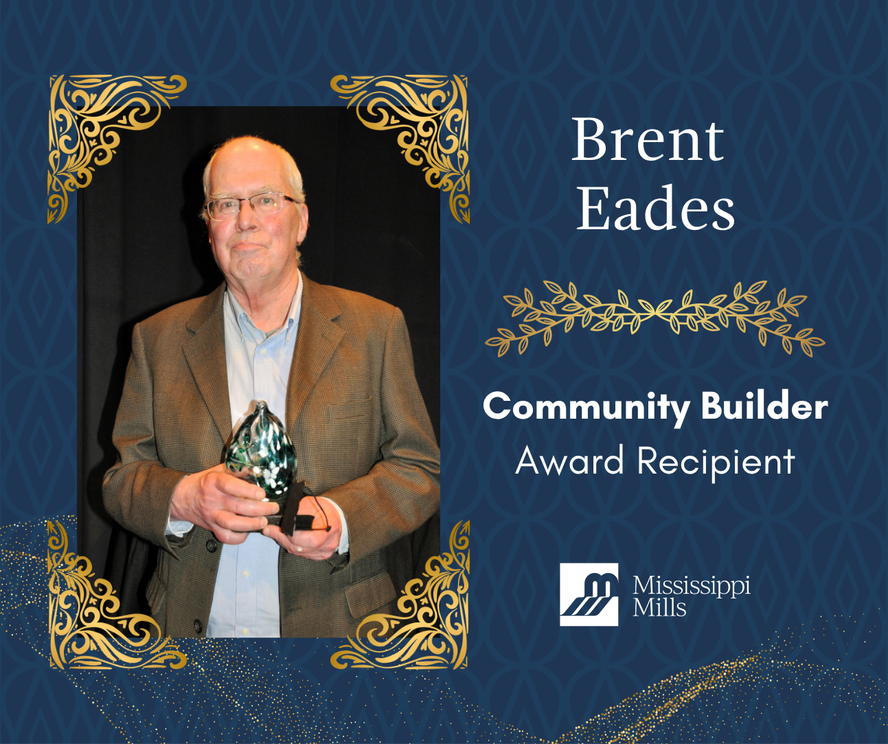 Navy background with gold accents displays a photo of a balding man with white hair and glasses in a light blue shirt and brown blazer, holding an award. White text reads 'Brent Eades - Community Builder Award Recipient.'