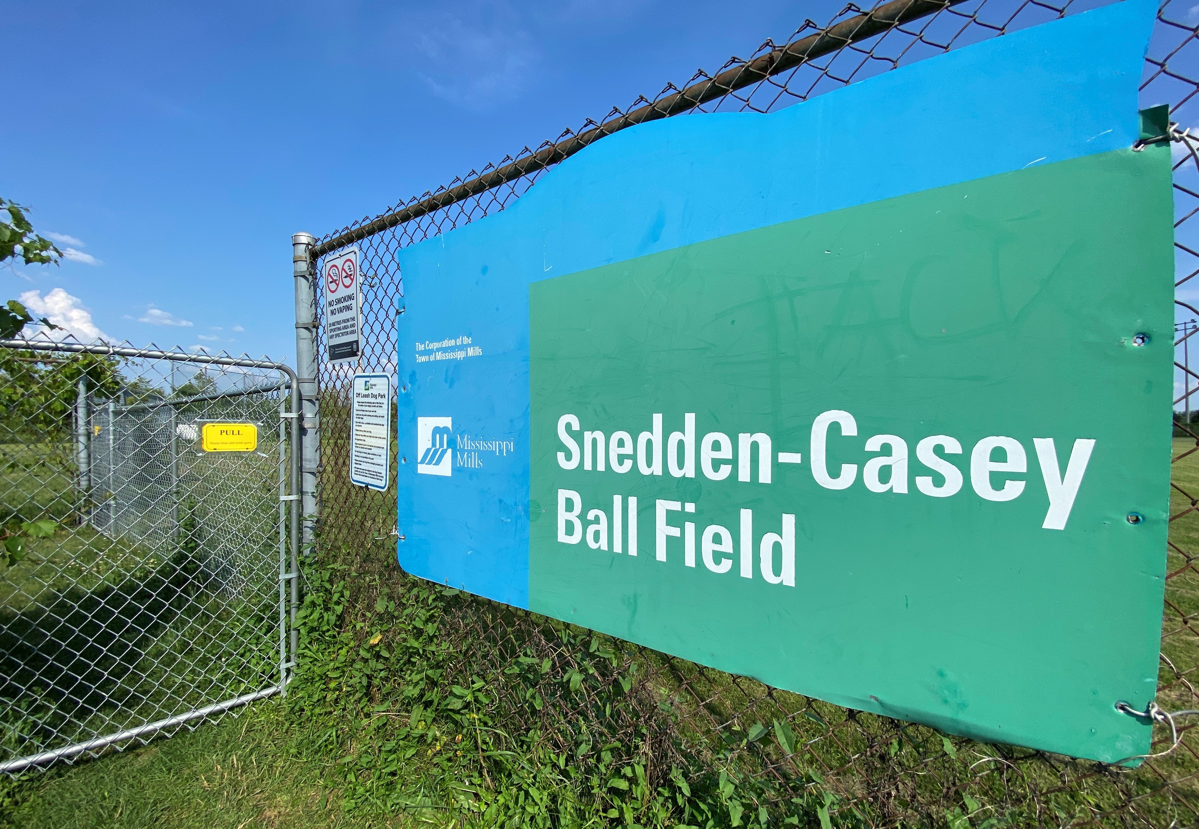 Sign on fence at ball diamond
