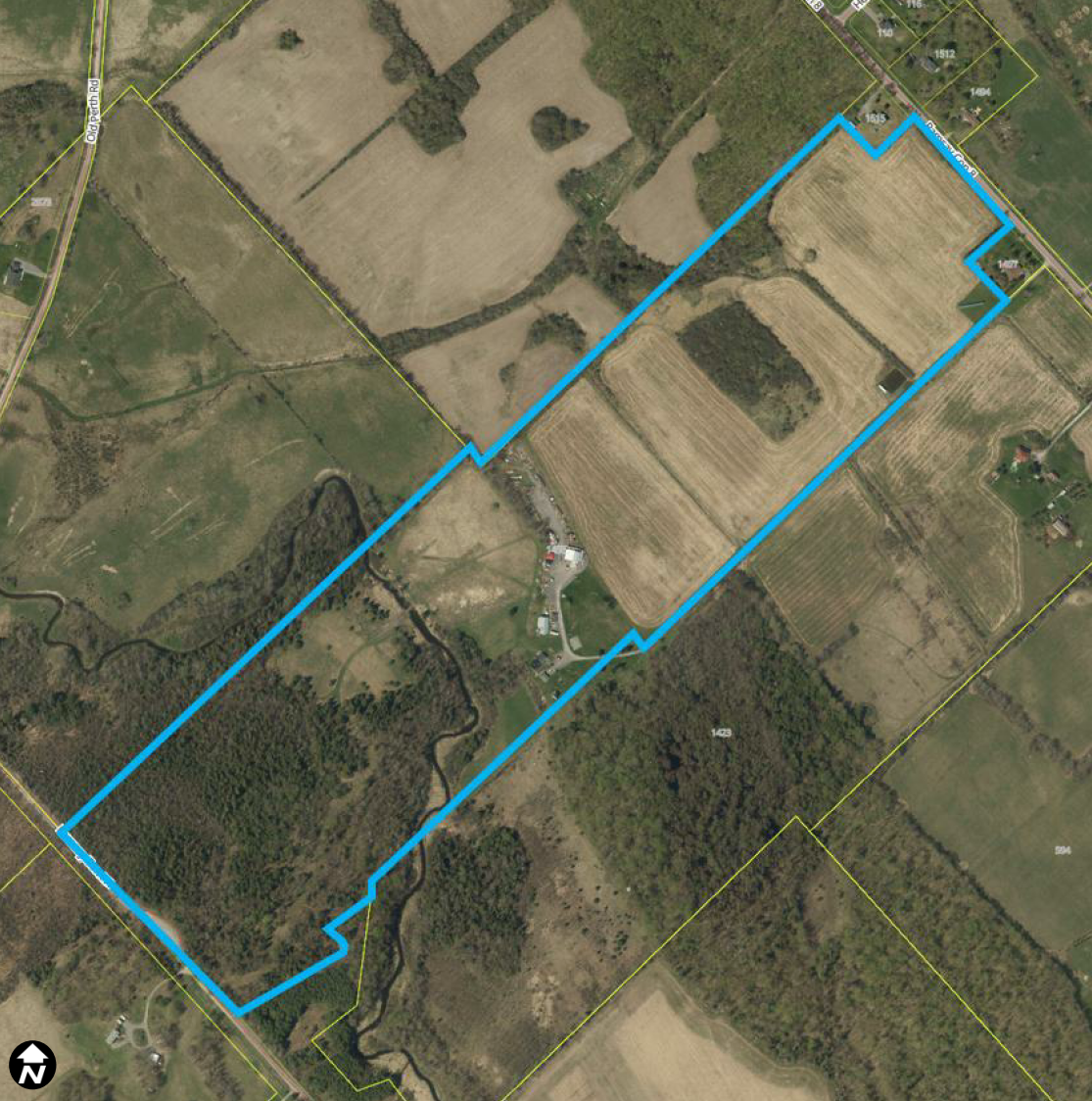 Satellite image of a rural area with a rectangular property outlined in blue.