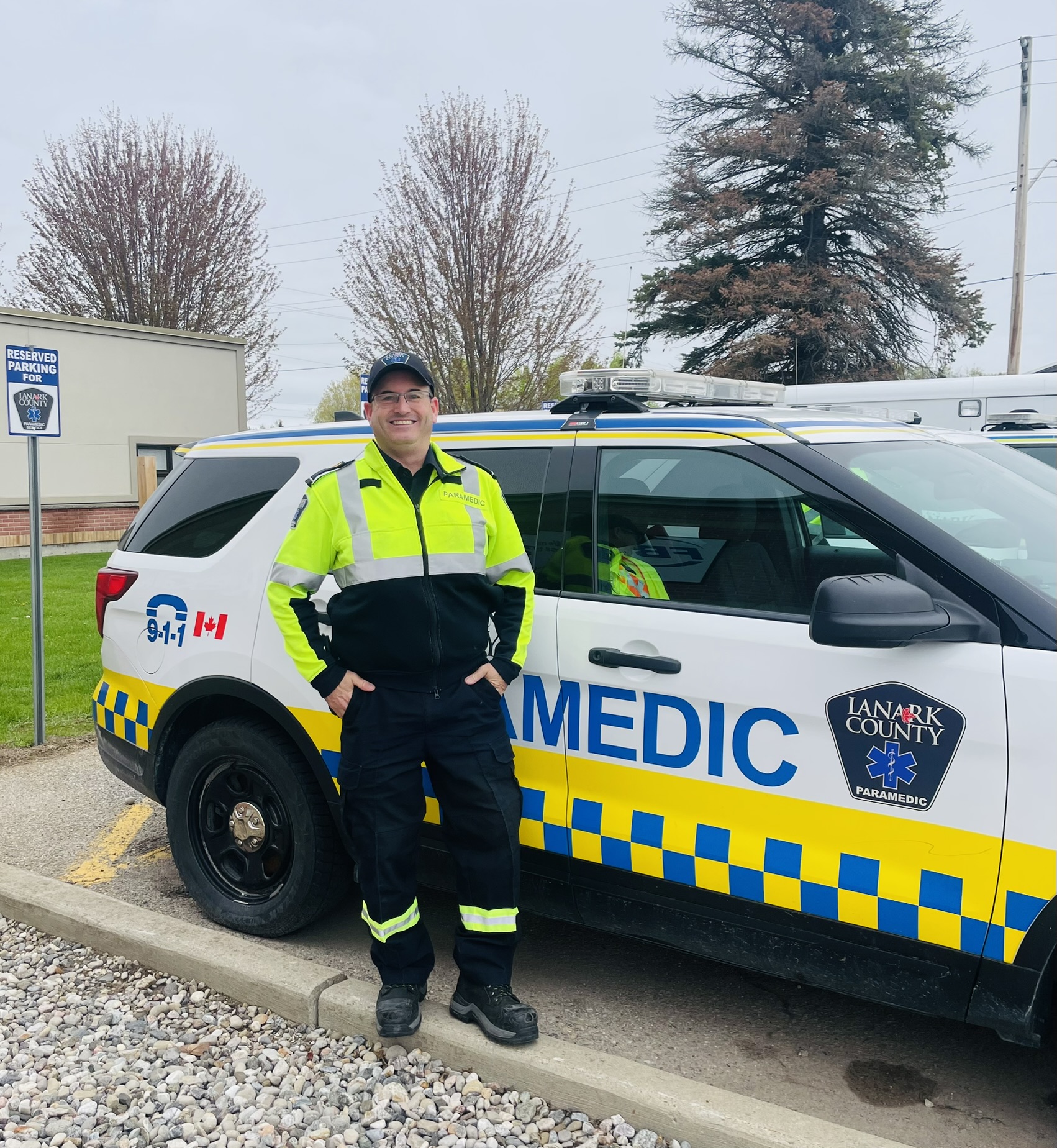 A paramedic stands beside a Lanark County Paramedic Service SUV.
