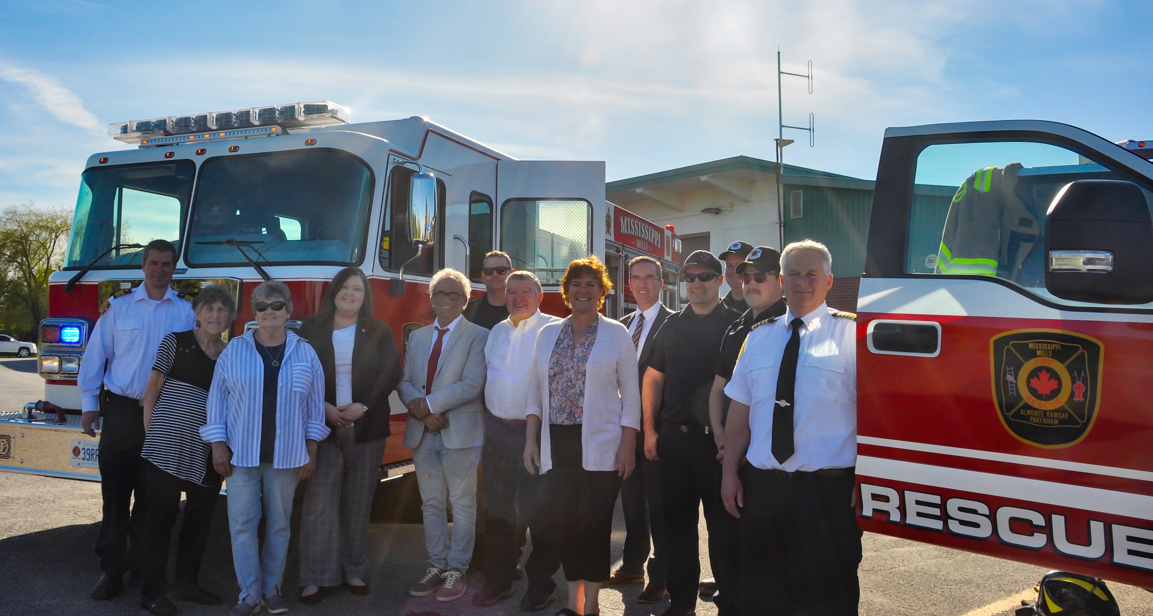 A group of people stand between two fire trucks