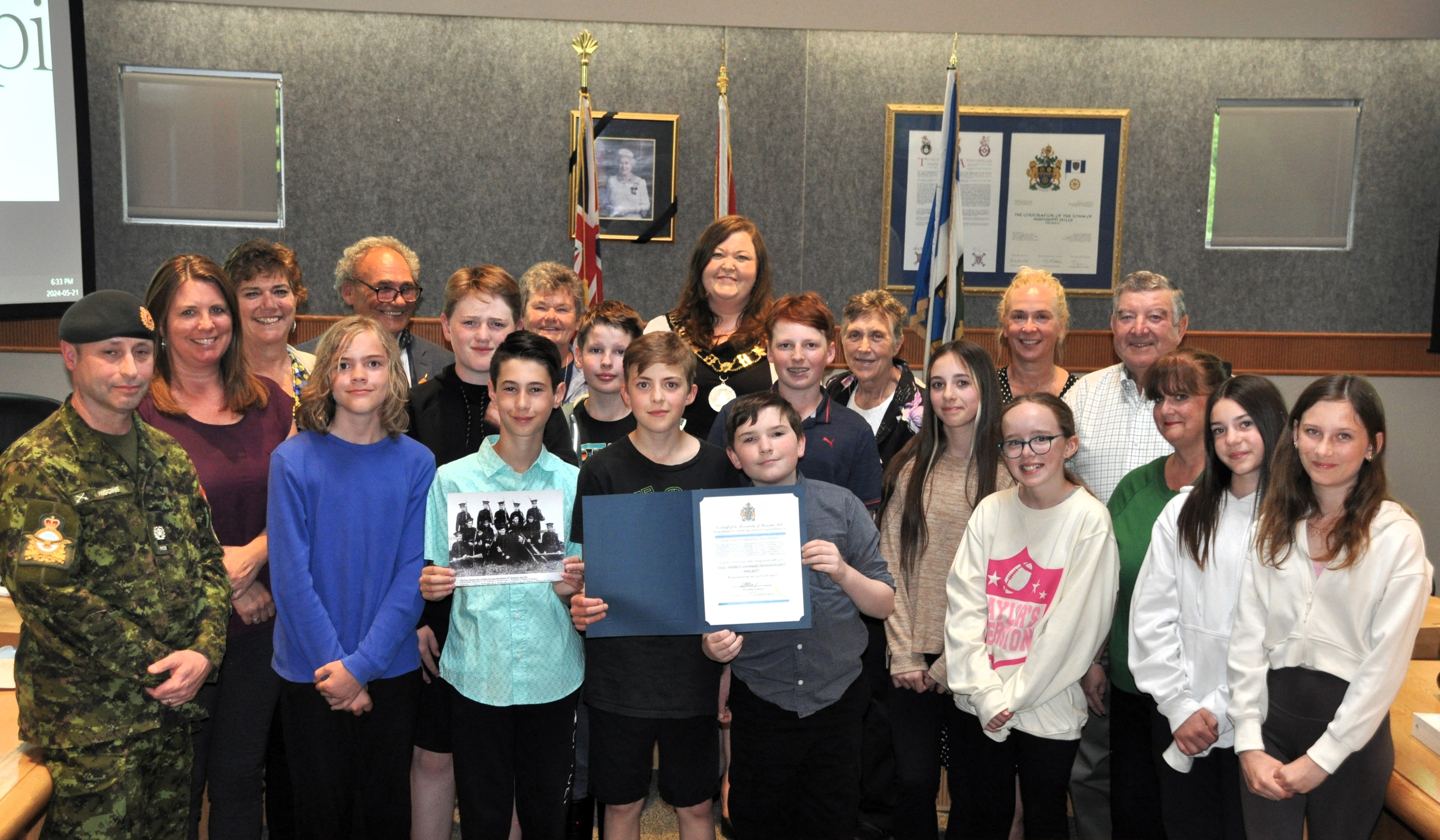 Council members stand with a group of students holding a certificate of appreciation