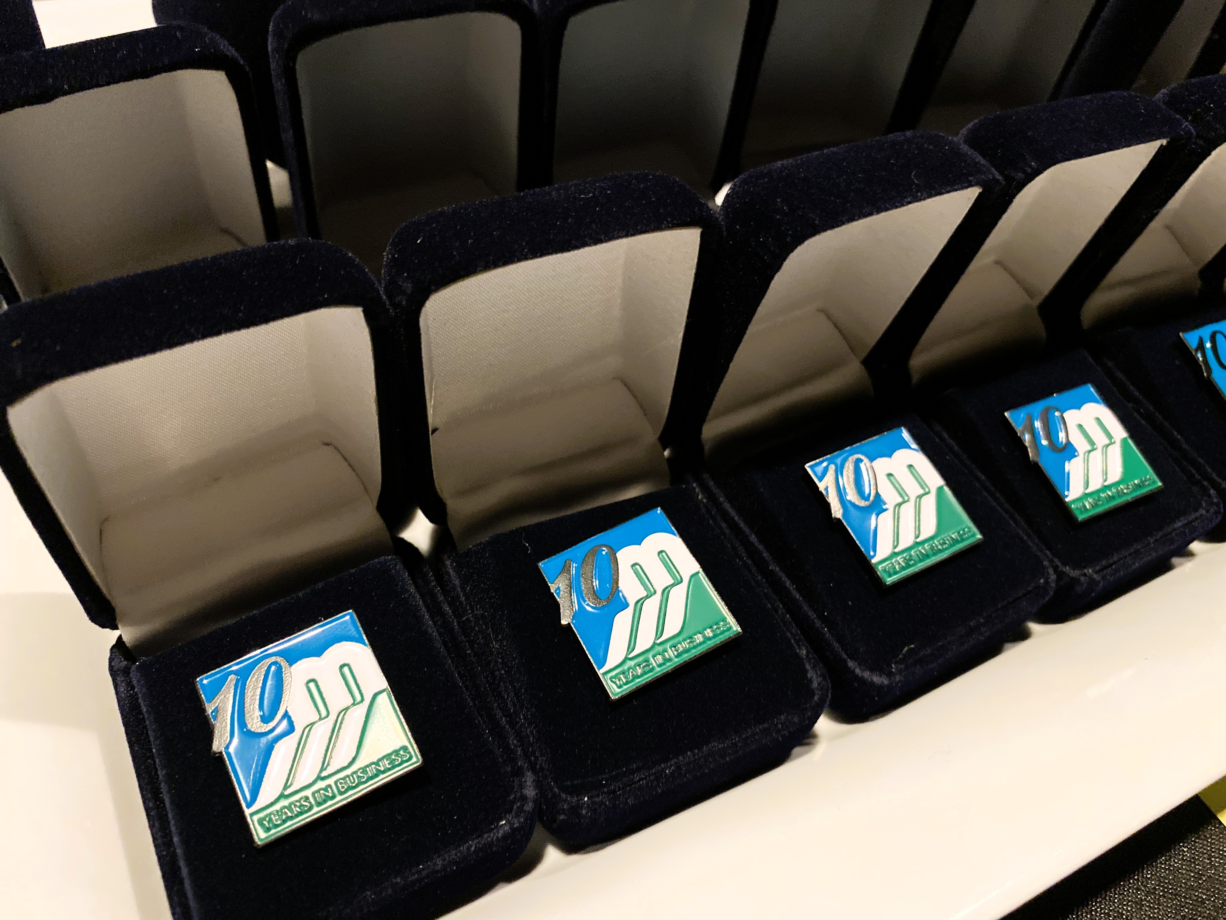 Pins with the Mississippi Mills logo and the number 10 sit in velvet boxes in a row