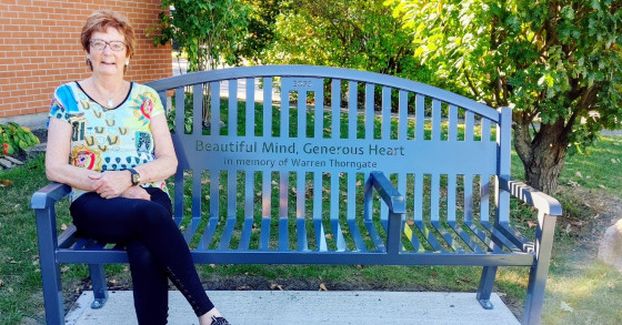 Photo of woman smiling and sitting on bench