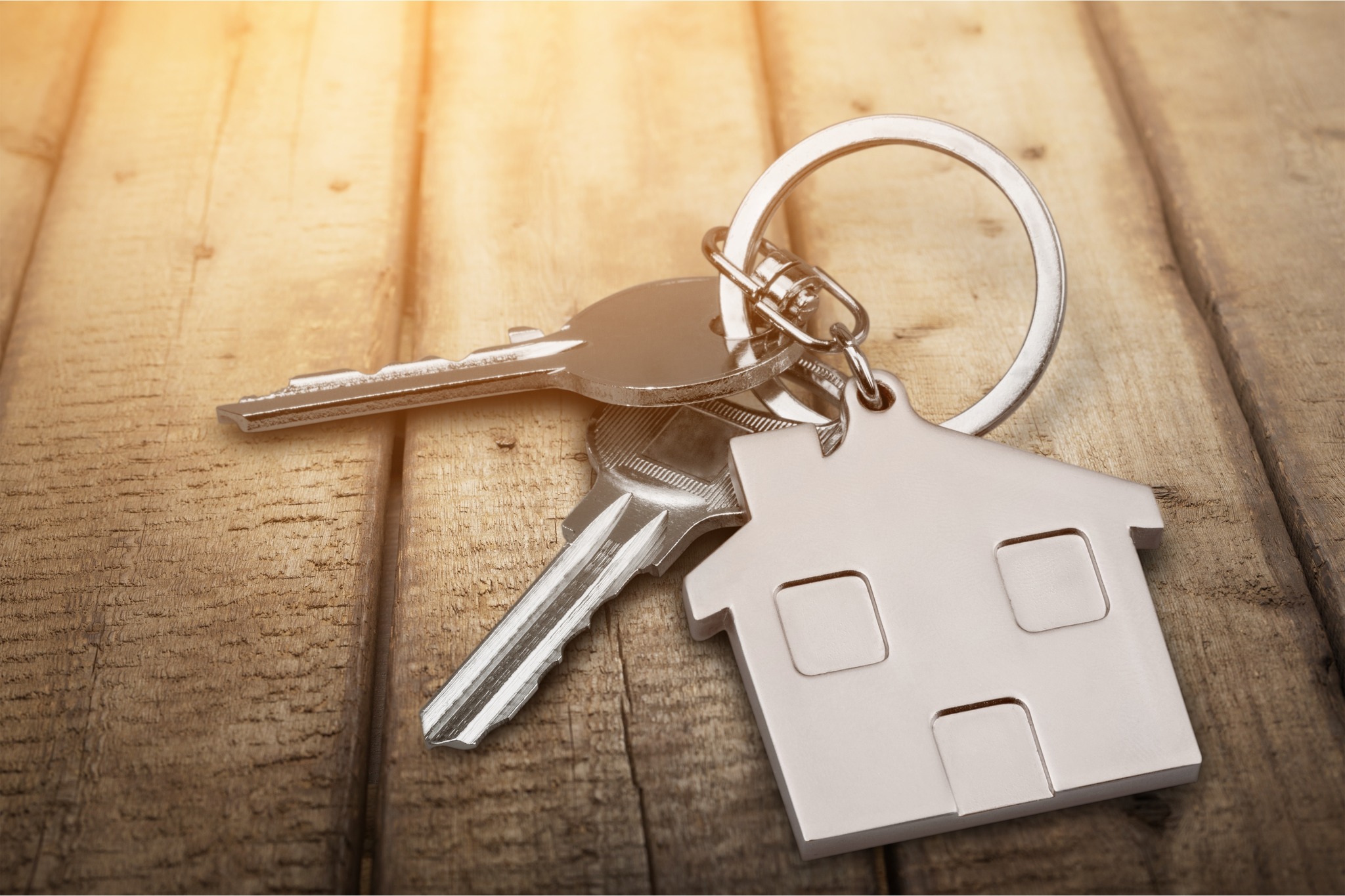 Set of silver keys on a keychain with a silver house attached to it