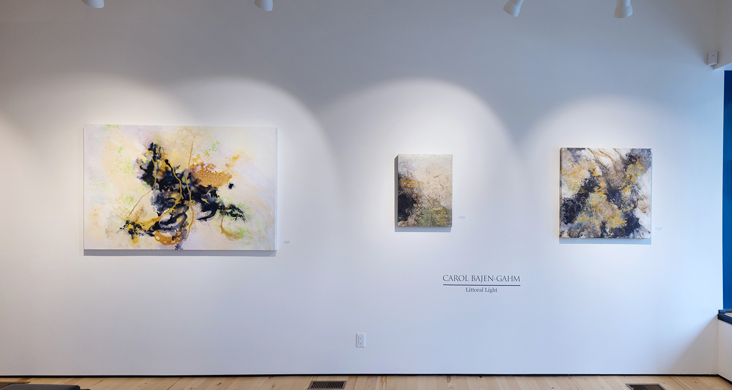 Photo of three pieces of artwork hanging in a gallery, against a white wall