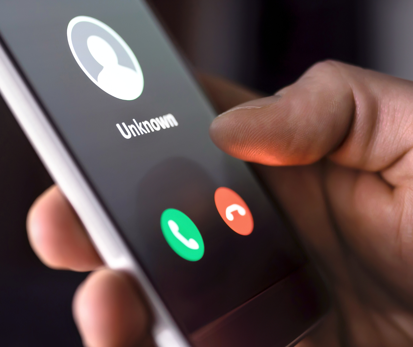 Hand holding cell phone receiving a call from an unknown caller