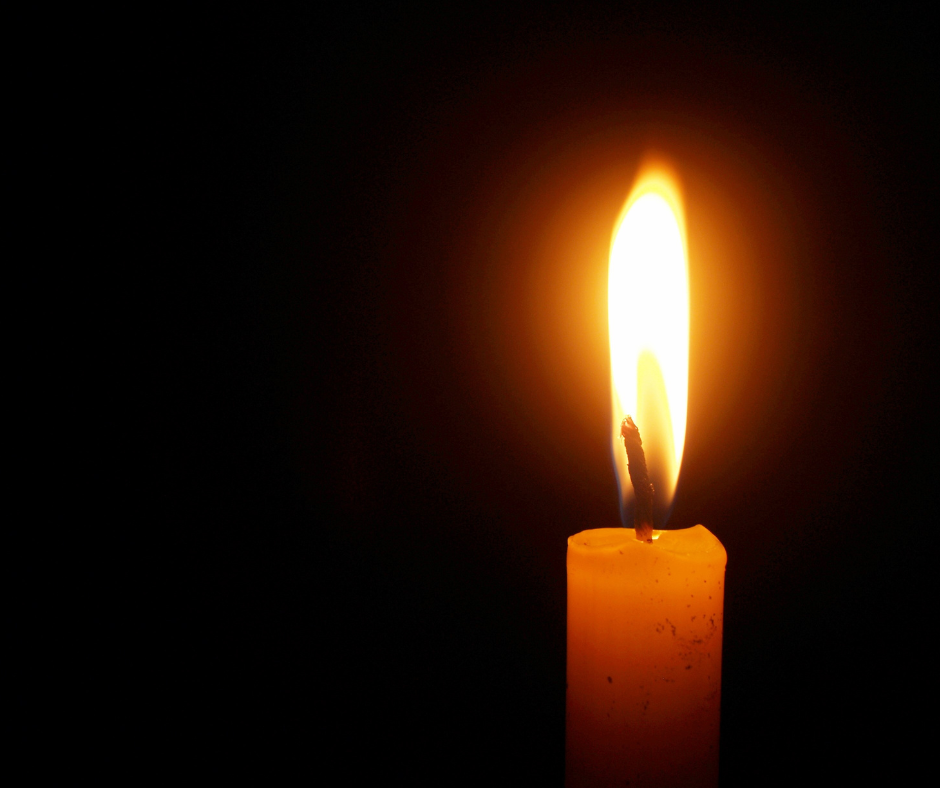 lit candle on black background