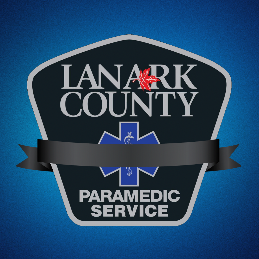 Black, blue and grey shield bearing the text 'Lanark County Paramedic Service' and a black ribbon over the top