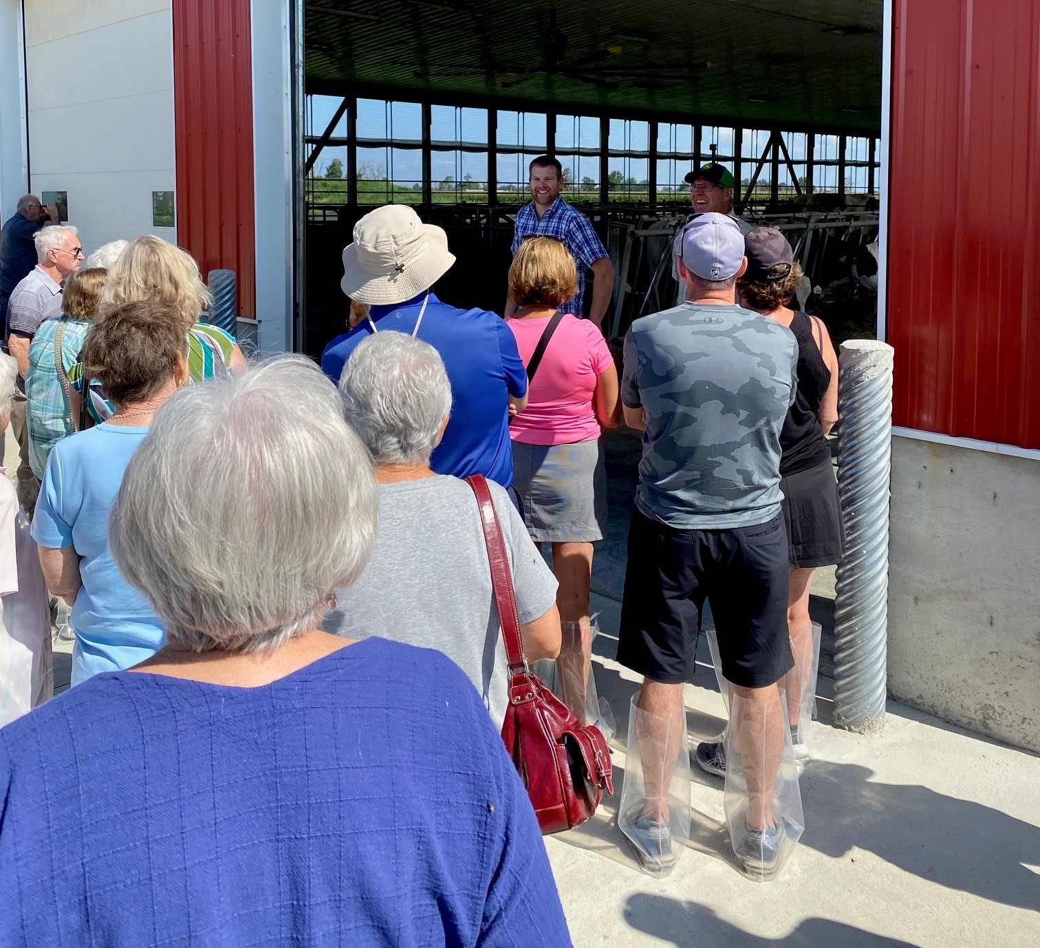 Group of people standing near the entrance of a red barn