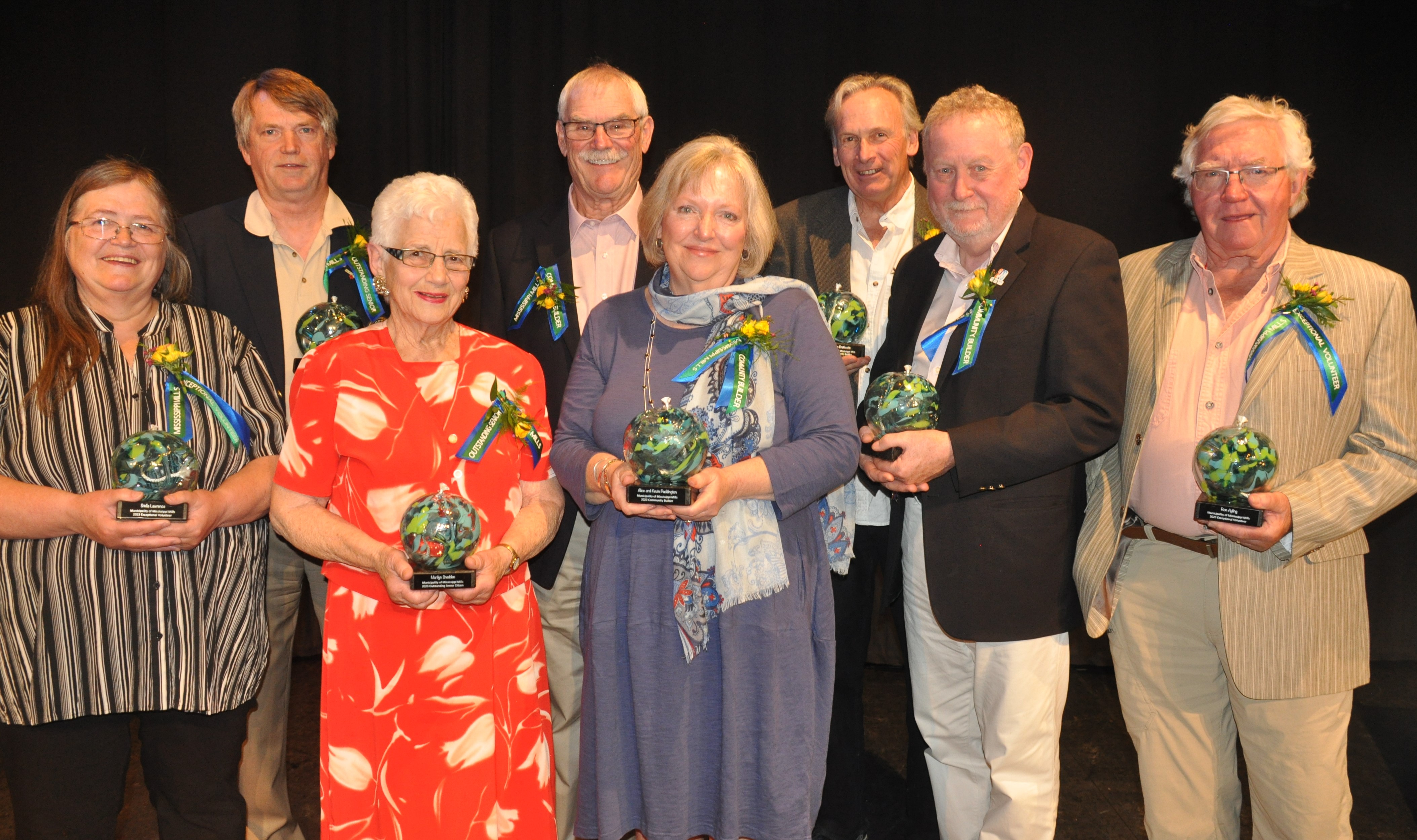 People stand with awards