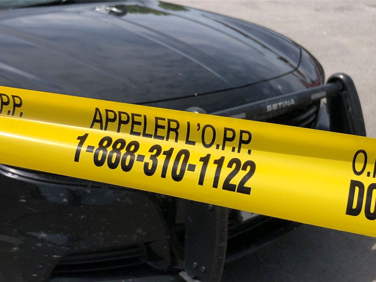 Ontario Provincial Police car with yellow tape in front of it.