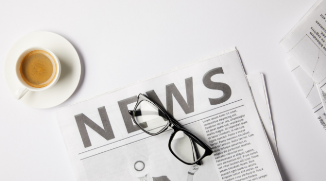 news printed on paper, cup of coffee and glasses