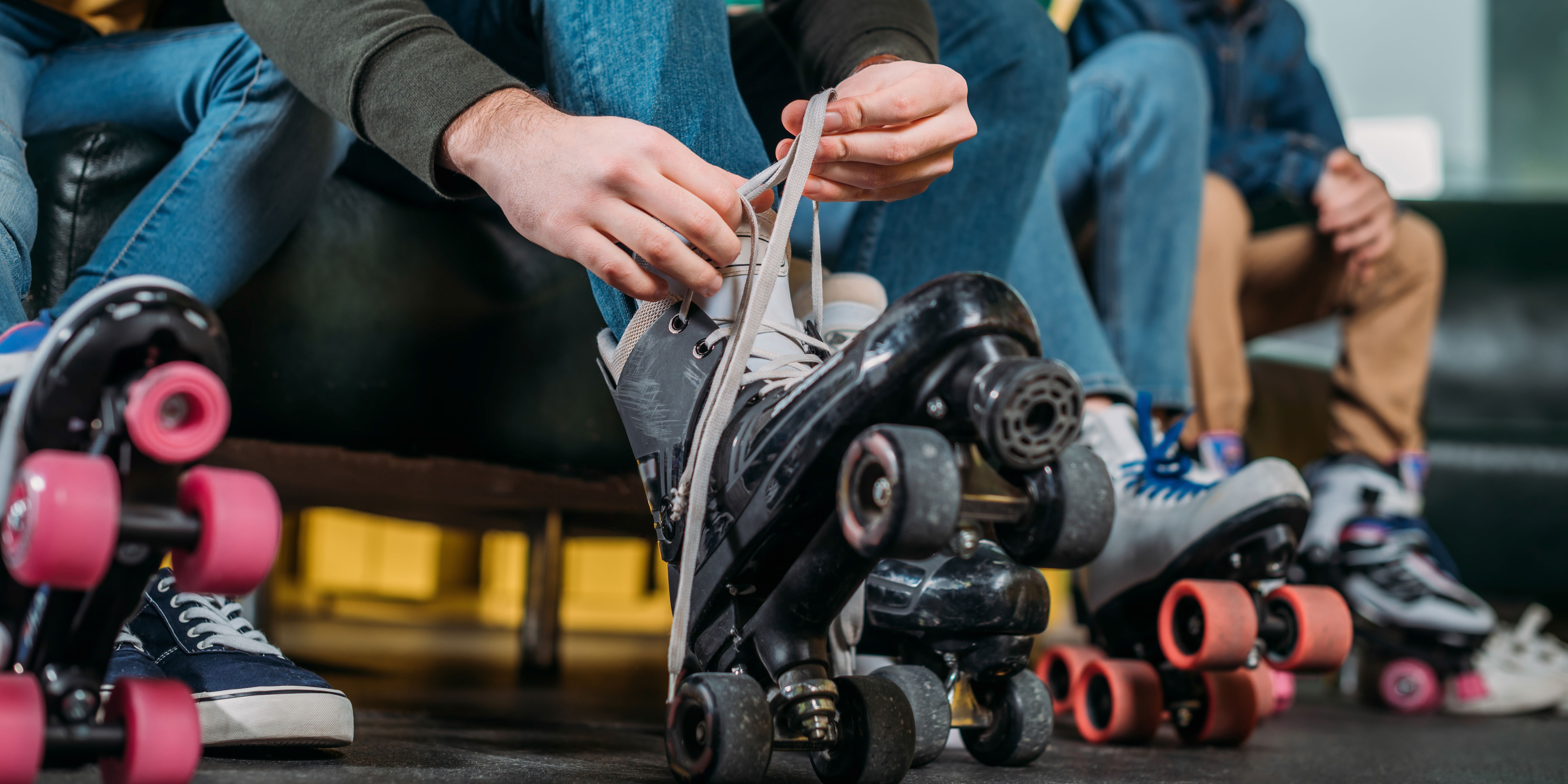 people lacing up roller skates