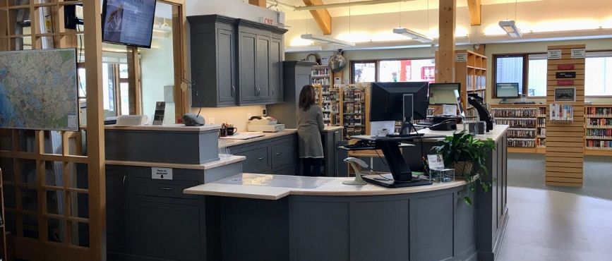 circulation desk at port carling library. Staff member can be seen working in the background.