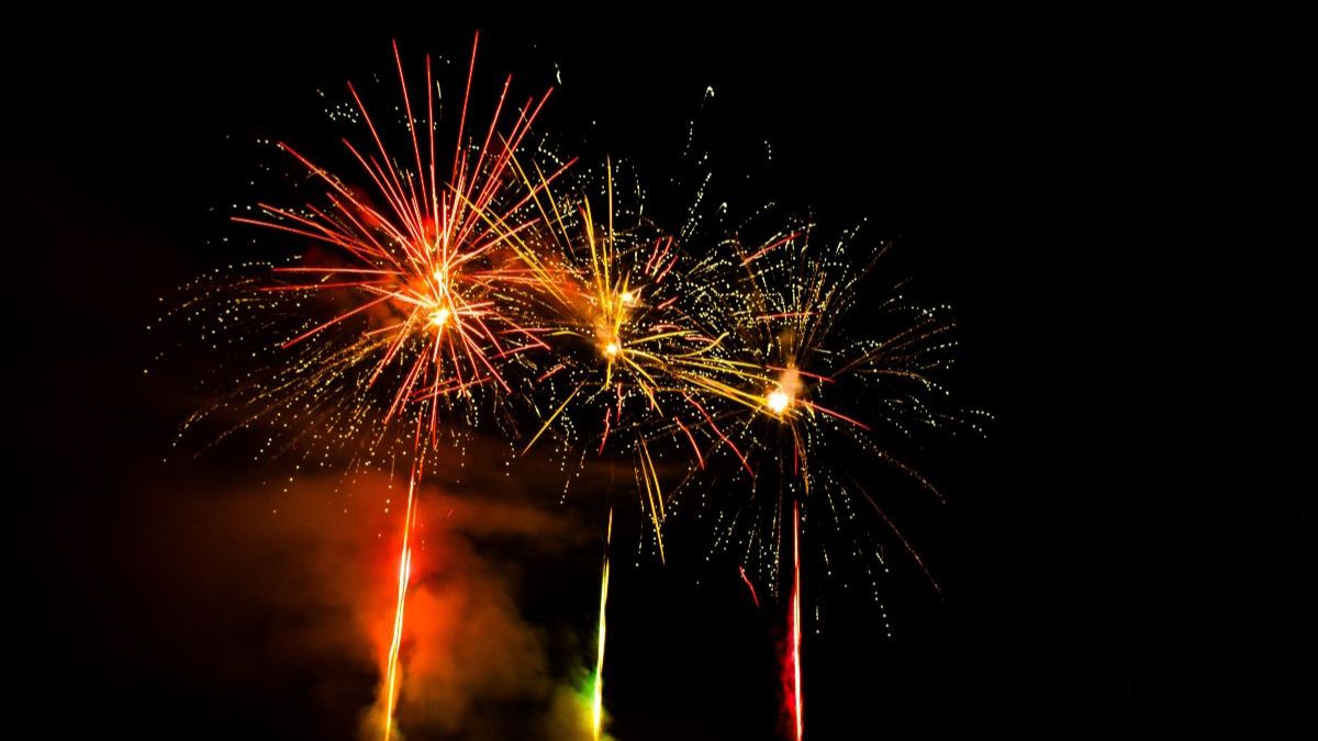 Three colourful fireworks going off in the night sky.