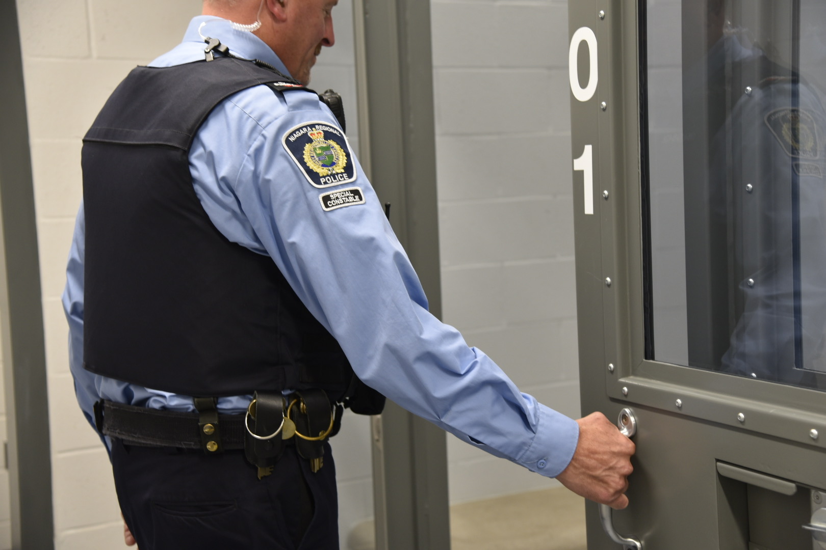 A special constable closing a cell door
