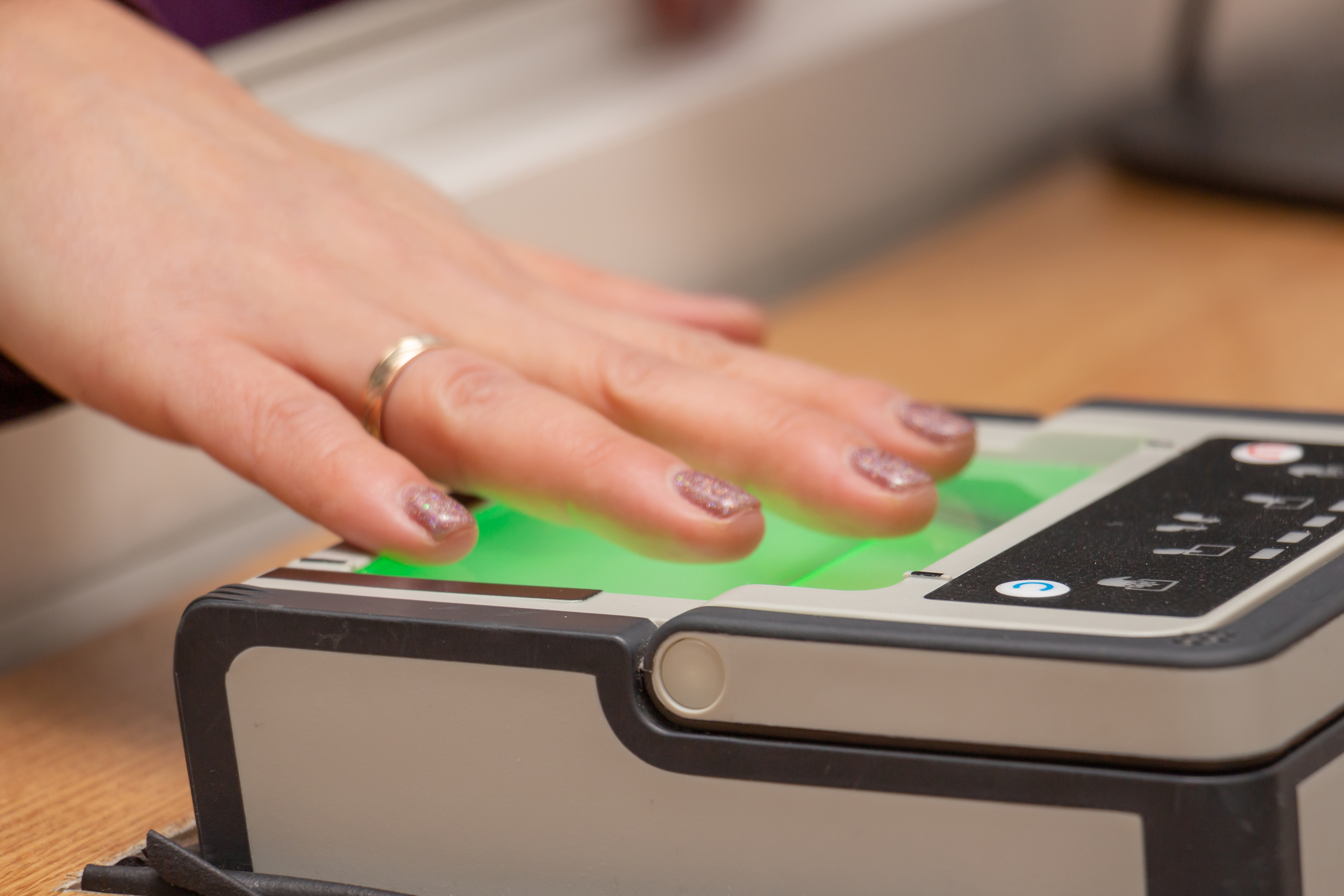 A hand on a fingerprint scanner