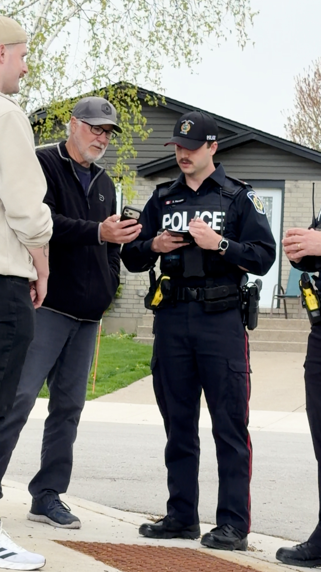 An officer being shown something on a cell phone by a member of the public